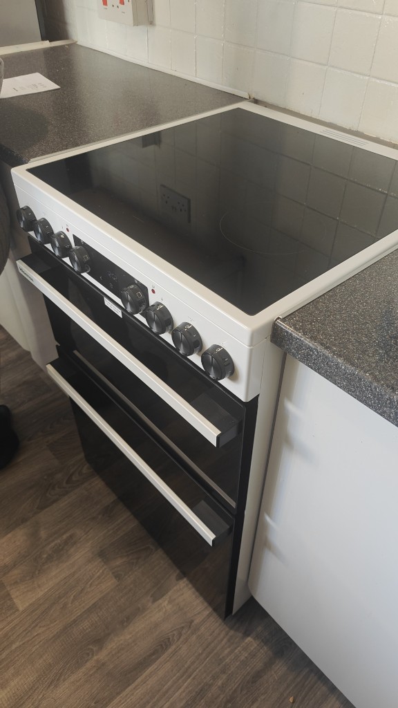 Electric cooker with ceramic hob installed between kitchen units