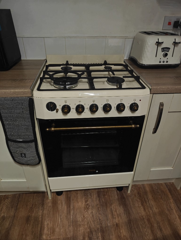 Cream cooker with brass fittings installed in a white kitchen